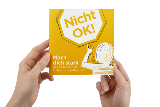 Hände halten die gelbe Broschüre